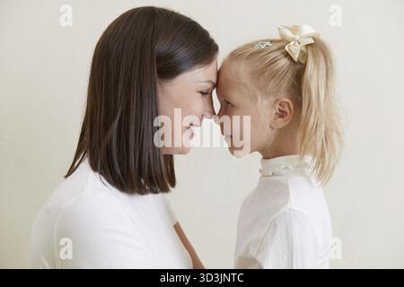 Fille joyeuse regardant la mère ravie de rire s'amusant, amour et soin concept de moment tendre Banque D'Images
