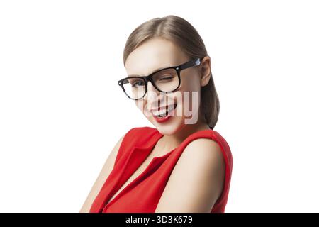 Portrait de belle jeune femme faisant un clin d'œil à la caméra tout en portant une robe rouge et des lunettes Banque D'Images