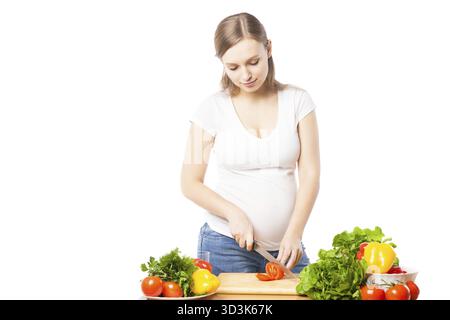 Portrait de femme enceinte préparant la salade.Studio shot Banque D'Images