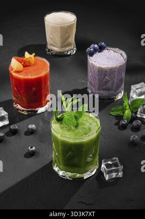 Nourriture, smoothies de fruits fraîchement mélangés de différentes couleurs et goûts dans le verre Banque D'Images