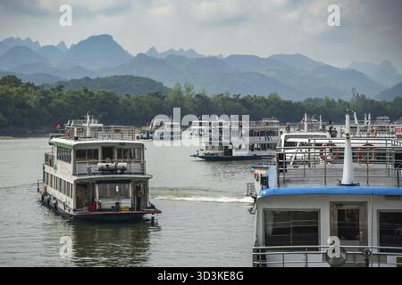 Guilin, Chine - Août 2019 : des bateaux touristiques plein de touristes partant pour une excursion sur la magnifique rivière Li de Guilin à Yangshuo Banque D'Images