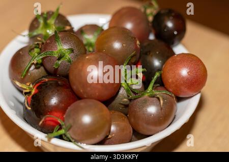 Tomates cerises foncées dans le bol Banque D'Images