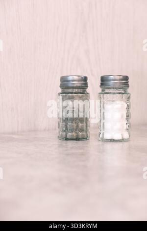 Salière et poivrière avec motif gaufré ou quadrillé et dessus en métal. Distribution de sel et de poivre dans les restaurants, les cafés ou à la maison Banque D'Images