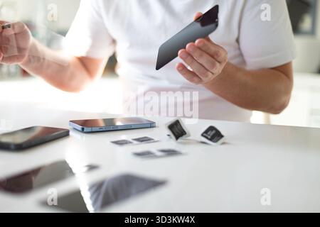 Le processus de remplacement d'un verre de protection sur un smartphone. Photo de haute qualité Banque D'Images