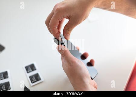 Le processus de remplacement d'un verre de protection sur un smartphone. Photo de haute qualité Banque D'Images