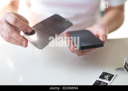 Le processus de remplacement d'un verre de protection sur un smartphone. Photo de haute qualité Banque D'Images
