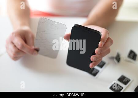Le processus de remplacement d'un verre de protection sur un smartphone. Photo de haute qualité Banque D'Images