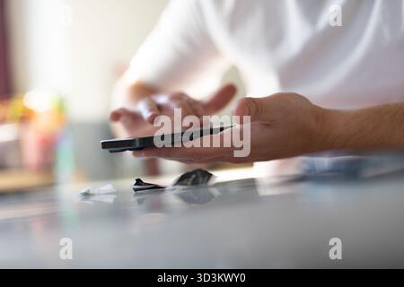 Le processus de remplacement d'un verre de protection sur un smartphone. Photo de haute qualité Banque D'Images