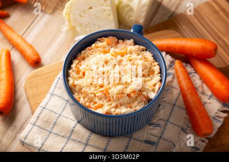 Coleslaw, salade à base de chou et de carottes râpées, est une recette facile, fraîche et saine connue dans de nombreux pays, généralement servie comme plat d'accompagnement à un Banque D'Images