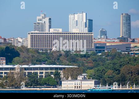 Istanbul, Turquie, 20 octobre 2025 ; la tour des hôtels Ritz-Carlton et Hilton au-dessus de Dolmabahçe et le front de mer de Beşiktaş avec Vodafone Arena visible Banque D'Images