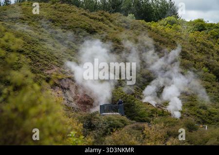 Craters of the Moon Geothermal Walk présente des évents de vapeur, de la boue bouillonnante et une activité géothermique sur une colline volcanique. Une personne voit le paysage f Banque D'Images