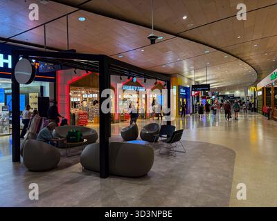 Aéroport d'Auckland, Nouvelle-Zélande. Vue intérieure du terminal international avec passagers, boutiques, notamment « autour de la Nouvelle-Zélande » et contemporain Banque D'Images