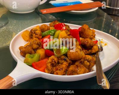 Poulet sucré et aigre. Un plat chinois-américain populaire composé de morceaux de poulet frits croustillants, de poivrons et d'ananas dans une sauce acidulée vibrante. S Banque D'Images