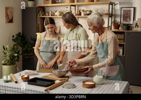 Fille caucasienne avec mère et grand-mère senior cuisson ensemble dans la cuisine Banque D'Images