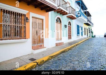 Des bâtiments colorés bordent une rue pavée, présentant une variété de styles architecturaux et des teintes vibrantes. Banque D'Images