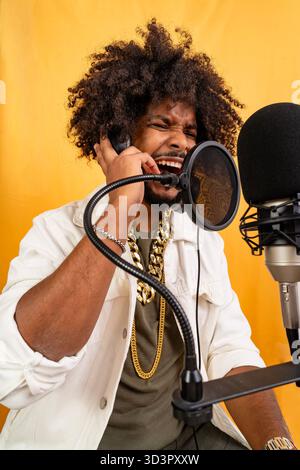Jeune homme noir jouant passionnément de la musique en studio d'enregistrement Banque D'Images
