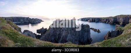 Vue panoramique du lever du soleil sur les falaises côtières accidentées Banque D'Images