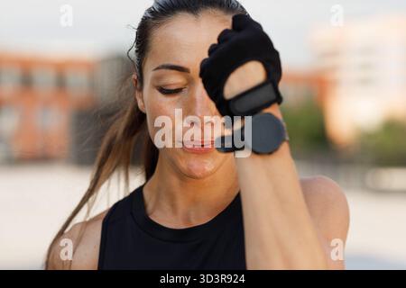 Gros plan Portrait détaillé élevé de jeune femme dans des gants faisant des coups d'ombre à l'extérieur avec les yeux fermés gros plan Portrait détaillé élevé de jeune fema Banque D'Images