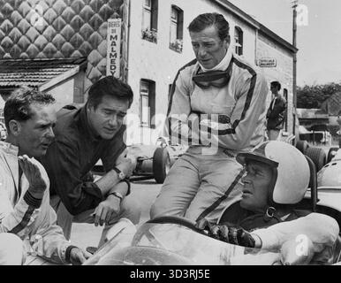 Le pilote automobile Phil Hill, le réalisateur John Frankenheimer, les acteurs Yves Montand et James Garner sur le tournage du film Grand Prix, USA 1966 Banque D'Images