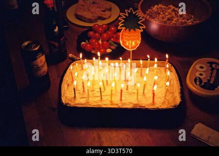 Gâteau d'anniversaire et collations sur une table, atmosphère festive, texture analogique, célébration décontractée, cadre de fête coloré. Banque D'Images