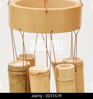 Mobile en bambou doré avec des coquillages suspendus à des cordes, balançant dans le vent arrière-plan de la nature isolée avec chemin de coupe Banque D'Images