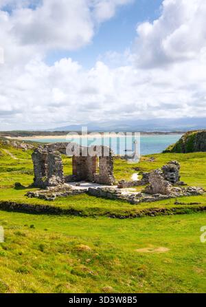 Vue vers les ruines de l'église St Dwynwen et une croix celtique sur l'île de Llanddwyn à Anglesey, pays de Galles Banque D'Images