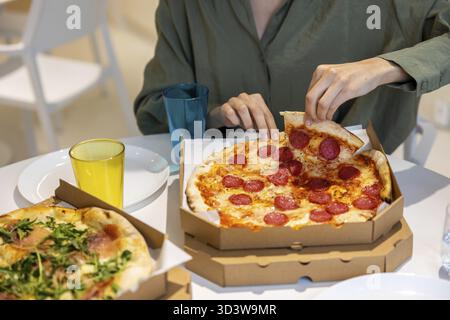 Heure de la pizza. Groupe de personnes déjeunant ensemble et mangeant de la pizza Banque D'Images