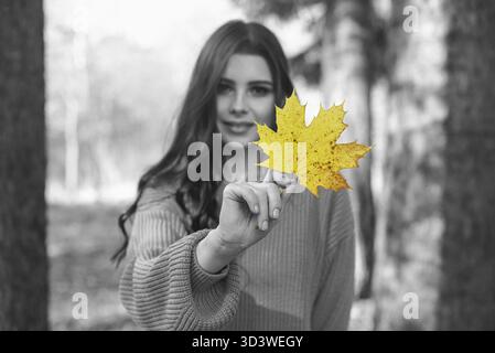 Belle femme avec feuille d'érable. Technique de tonification, concept d'automne Banque D'Images
