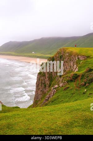 Un photographe sur les falaises au-dessus de Rhossili Bay Beach, Swansea, pays de Galles Banque D'Images