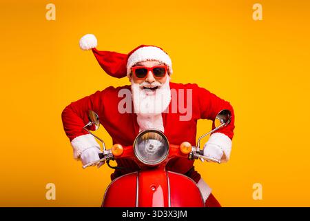 Le Père Noël sur une moto rouge vif apporte plaisir festif et esprit de Noël pour les campagnes de vacances et le marketing saisonnier Banque D'Images