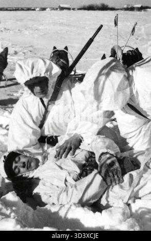 Pendant la guerre d'hiver de 1940 entre la Finlande et la Russie, un soldat finlandais blessé en camouflage a été transporté vers un endroit plus sûr via un traîneau à chiens. Banque D'Images