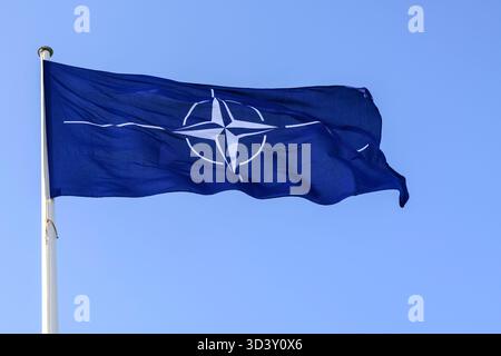Schoenefeld, Deutschland. 07 novembre 2025. Dans l'image, de gauche à droite : un drapeau sur un mât de drapeau bat dans le vent, logo OTAN OTAN, bleu et blanc, Conférence de presse 'arrivée du P-8A Poséidon le 7 novembre 2025 - Une nouvelle ère de reconnaissance maritime allemande commence' suivie par - communiqué de presse du ministre fédéral de la Défense Boris Pistorius et commandant de la Marine allemande Vice-amiral Axel Deertz à Berlin - Schoenefeld - terminal gouvernemental de l'aéroport de Ber, 7 novembre 2025 (photo de HMB Media/Uwe Koch/Sipa) Alamy USA Live News) Banque D'Images