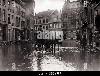La rue principale, de Parade, à Venlo, aux pays-Bas, a été complètement inondée lors des inondations de 1926. Les gens marchent le long de planches de bois de fortune tandis qu'une charrette tirée par des chevaux est visible au milieu de la rue. Banque D'Images