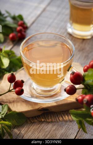 Une tasse de thé rose hip sur une table en bois Banque D'Images