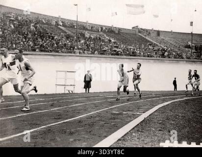 Un instant des Jeux olympiques d'Amsterdam de 1928 montre la course de relais masculine 4x100 mètres, avec des athlètes qui passent le relais pendant la course. Banque D'Images