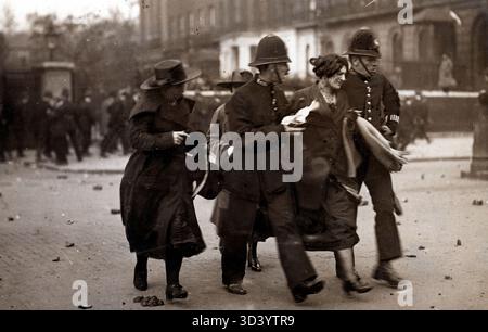 Une femme blessée est escortée par deux officiers lors des émeutes de Downing Street, Londres, Angleterre, en 1920. La photo fait partie d'une série de quatre images documentant les troubles. Banque D'Images