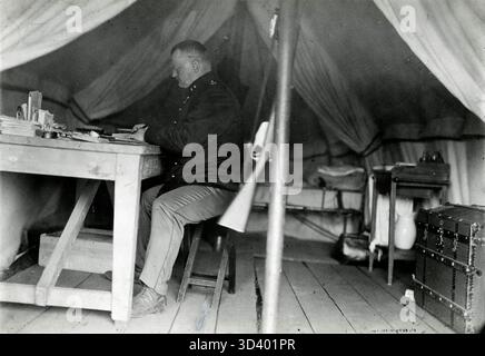 Le lieutenant Agterberg travaille derrière une table en bois dans sa tente dans un camp de l'Association royale néerlandaise de défense 'Volksweerbaarheid' à Laren, pays-Bas, 1912. Banque D'Images