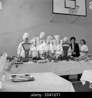 Une photo d'archives de 1984 montre tout le personnel de la cuisine et de la cantine pour une conférence à la Maison de la culture Artyom (DK) à Sloviansk, RSS d'Ukraine. Le groupe de neuf femmes, la plupart en chapeaux de chef, pose derrière la ligne du buffet. La cantine a été temporairement installée dans le gymnase, avec un panier de basket-ball clairement visible sur le mur derrière eux. Cela capture la grande équipe qui a accueilli l'événement soviétique officiel. Cela montre la vie quotidienne dans le Donbass paisible avant la guerre. Banque D'Images