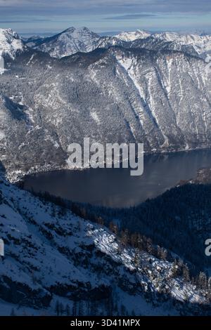 Vallée alpine enneigée avec le lac Hallstatt vu de haut au-dessus des montagnes de Dachstein. Banque D'Images