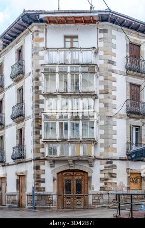 Bâtiment blanc traditionnel avec galerie de verre fermée à plusieurs étages, architecture historique, détails de coin de pierre, façade altérée, rue urbaine Banque D'Images