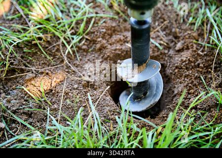 Foret pour tarière de jardin creusant un trou dans le sol pour la plantation et les travaux de construction Banque D'Images