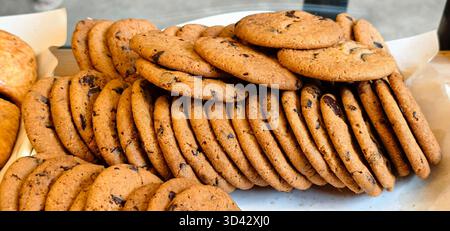 Grande pile de biscuits aux pépites de chocolat fraîchement cuits. Banque D'Images