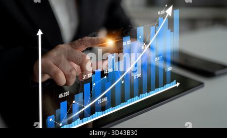 Un cadre professionnel mettant en vedette une personne interagissant avec des tableaux et des graphiques numériques sur une tablette, illustrant la croissance de l'entreprise et l'analyse des données pour Banque D'Images