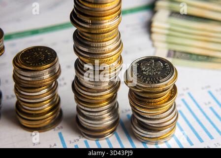 Gros plan de plusieurs grandes piles de pièces de monnaie sur les graphiques financiers, symbolisant la prospérité et la stabilité. Banque D'Images