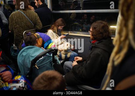 People using their phones and enjoying time on a busy Paris metro train. Paris, France Banque D'Images