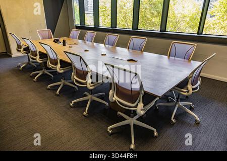 Salle de conférence vide avec table en bois et chaises de luxe sur roues Banque D'Images
