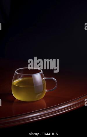 Tasse de perfusion jaune sur une table luxueuse avec un fond noir Banque D'Images