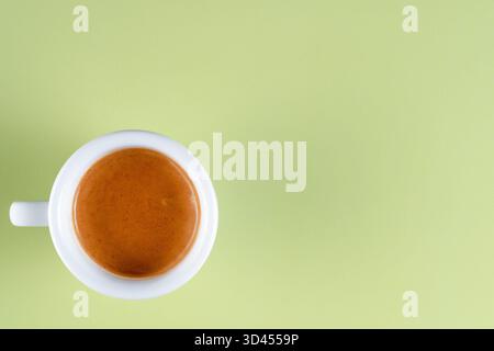 Une vue de dessus de double espresso dans une tasse blanche sur fond vert Banque D'Images