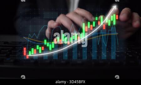 Cette image montre une personne interagissant avec un clavier tandis que les données boursières s'affichent à l'écran, mettant en évidence les tendances de croissance financière dans un Banque D'Images