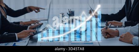 L'équipe commerciale participe à une réunion, analysant les données de croissance affichées sur un ordinateur portable. L'image reflète la collaboration, la stratégie et le professionnalisme dans un Banque D'Images
